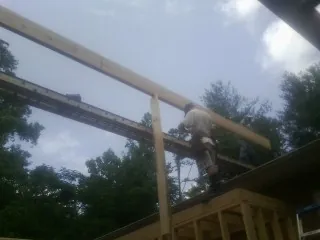Carpenter setting a ridge beam over a new addition frame — Ice Dam Removal by Roofing Brothers in Laurys Station
