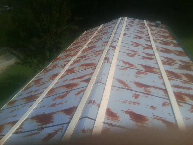 Rusted metal roof panels with new wood purlins before replacement — Storm Damage Roof Repair in Laurys Station by Roofing Brothers