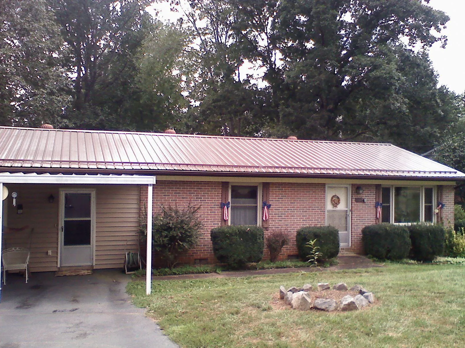 Bronze metal roof and carport on a brick ranch home — Roof Repair work by our crew in Laurys Station